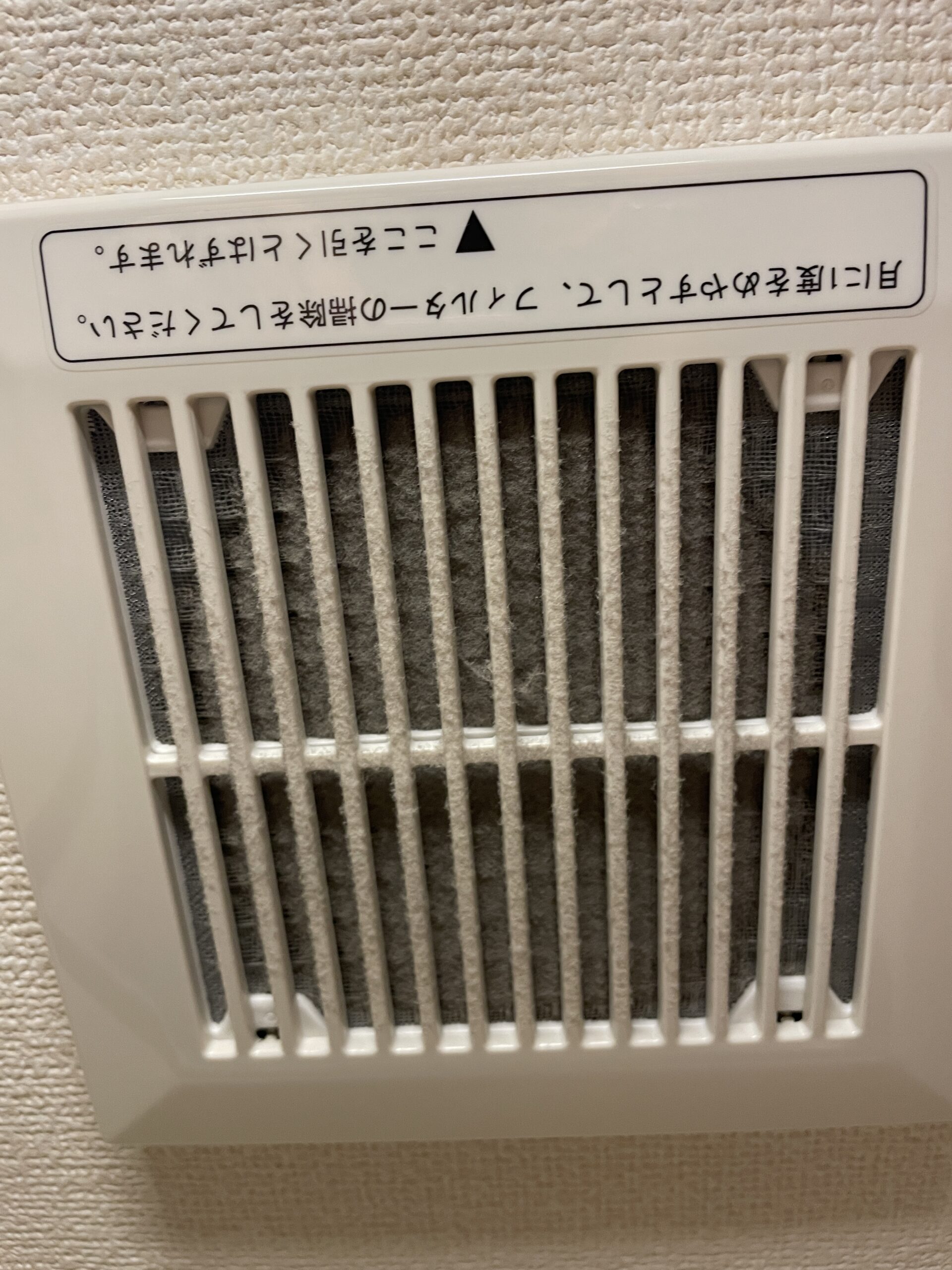 洗面室の換気扇フィルター掃除前の状態。カビで黒く汚れている
