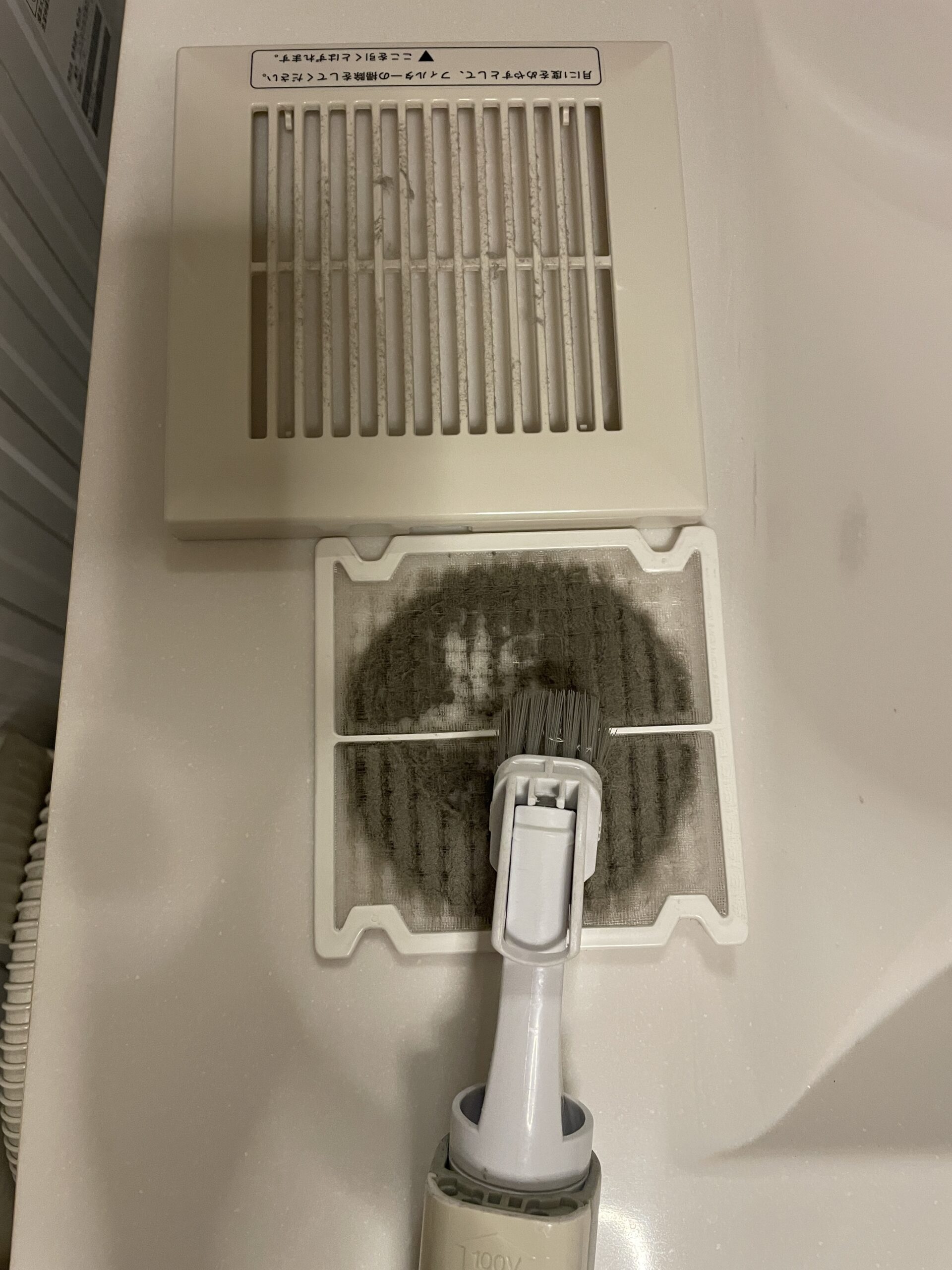 洗面室の換気扇フィルターをぬるま湯と洗剤で水洗いしている